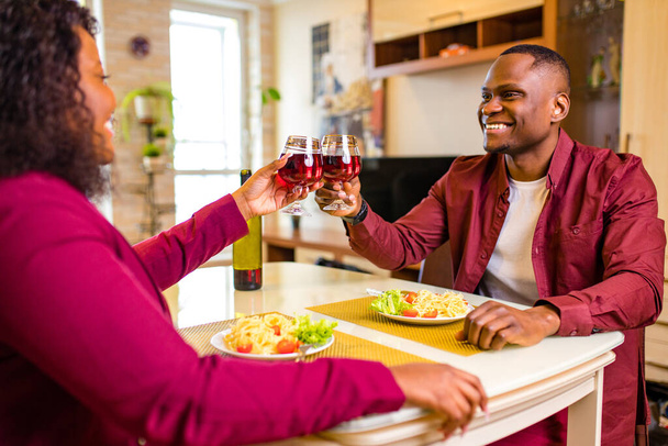 african american couple in love drinking wine from glasses and eating italian pasta in living room 14 february valentines day - Foto, Imagen