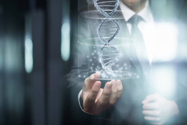 Obchodní muž ukazuje molekulu DNA na rozmazaném pozadí. - Fotografie, Obrázek