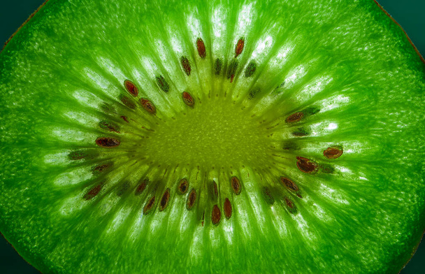 Slice of kiwi fruit close-up on dark background. Horizontal. space for text - Foto, afbeelding