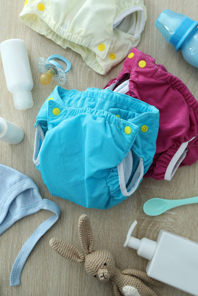 Concept of baby clothes with reusable diapers on wooden background - Foto, Imagem