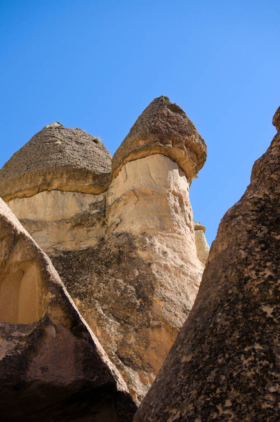 Close-up vista para cima das famosas chaminés de fadas ou cogumelos de pedra Multihead em Pasaba Valley perto de Goreme. Fundo azul do céu. Destino de viagem popular na Turquia. Património Mundial da UNESCO. - Foto, Imagem