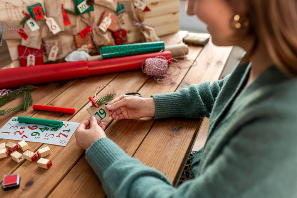 woman making advent calendar on christmas at home - Zdjęcie, obraz