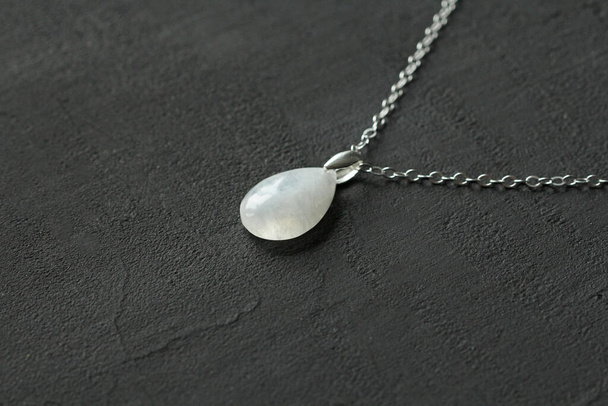 Moonstone, adularia natural pendant, necklace drop shape. Short necklace of Moonstone. Handmade jewelry made from natural stones. Modern Author's jewelry. Natural Moonstone pendant on silver chain. - Fotografie, Obrázek