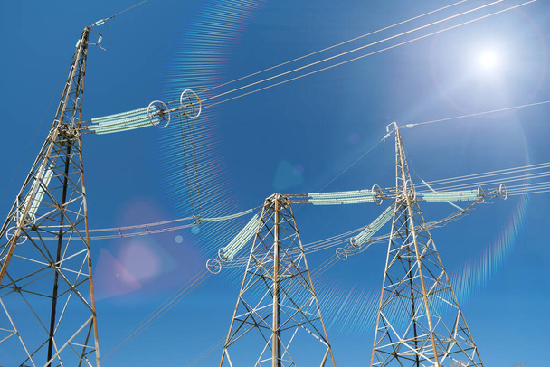 Grandes torres de transmissão de energia elétrica, linhas e sol - Foto, Imagem