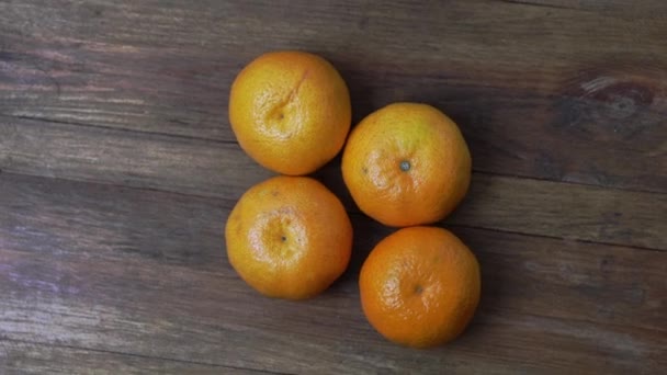 Close-up zicht van langzaam roterende rijpe oranje mandarijnen fruit isolatie op hout achtergrond. - Video