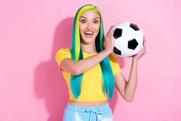 Photo of young beautiful amazed female catch football ball sportive player have fun isolated on pink color background - 写真・画像