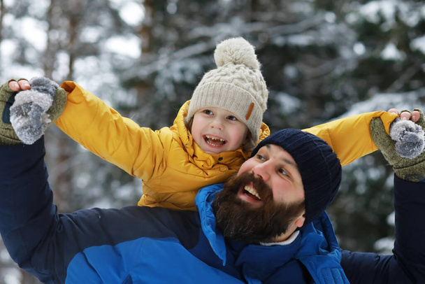 Familia feliz jugando y riendo en invierno al aire libre en la nieve. Parque de la ciudad día de invierno. - Foto, imagen