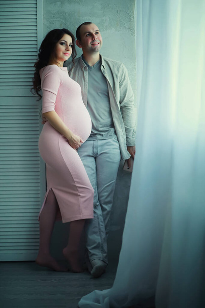 Krásná těhotná dívka s velkým břichem. Mladý manželský pár. Manžel čeká těhotnou ženu. Pár čekající na porod dítěte. - Fotografie, Obrázek
