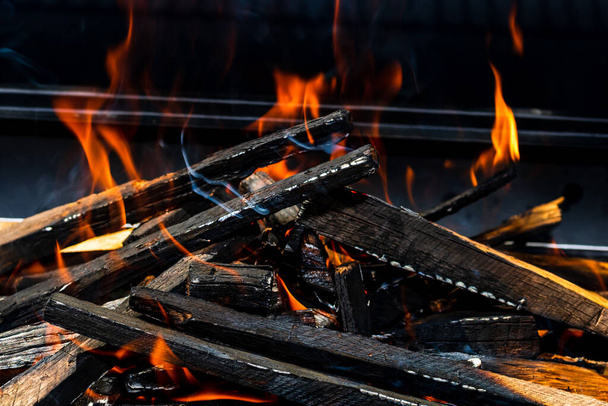 Barbecue grill pit met gloeiend en vlammend warm open vuur met rode vlam, hete houtskool briketten en sinaasappels - Foto, afbeelding