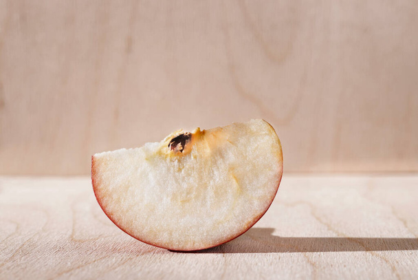 Slice of  red Annurca apple on wooden background ,fruit cultivated in Southern Italy - Φωτογραφία, εικόνα
