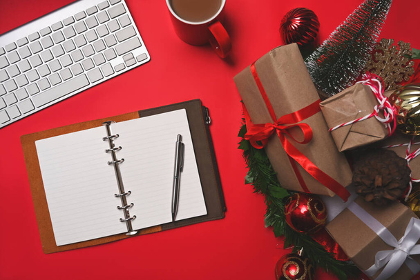 Cadeaux de Noël enveloppés, cône de pin et tasse de café sur fond rouge. - Photo, image