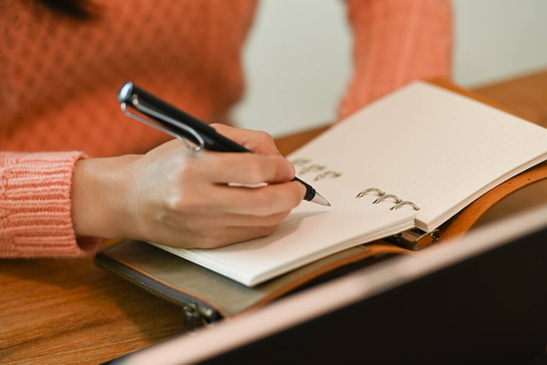 Close-up vista jovem mulher em camisola quente fazendo notas para seu diário.  - Foto, Imagem