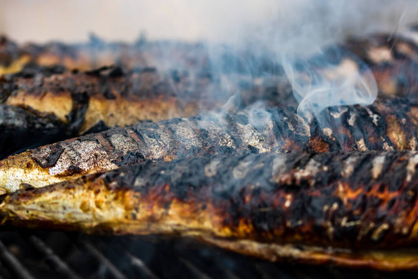 Tasty grilled fish on a charcoal grill. Fresh fish barbecue - Photo, Image