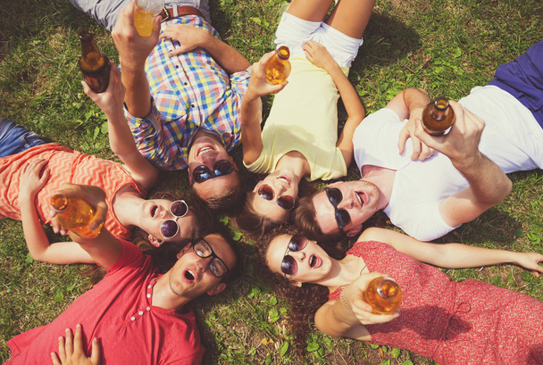People lying on the grass with drinks - 写真・画像