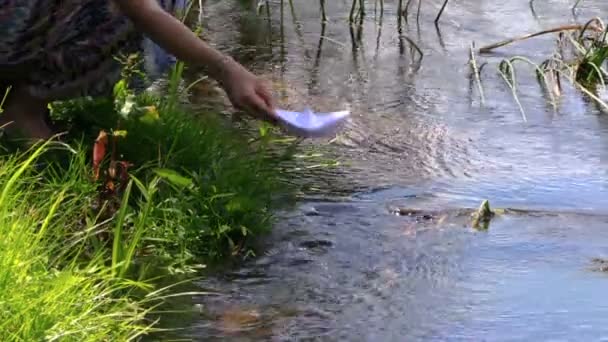 dromerig laat meisje papier origami schip boot drijven op rivierwater - Video