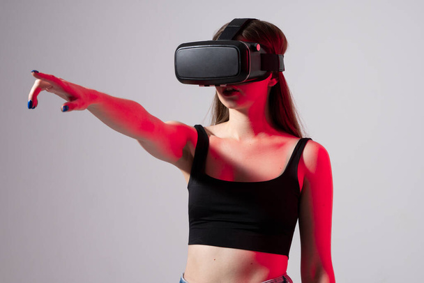 Happy young woman playing on VR glasses. Virtual reality concept with young girl having fun in virtual reality goggles. Metaverse. - Φωτογραφία, εικόνα