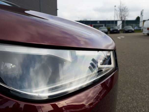 Nuevo xenón llevó la luz láser de un coche de lujo rojo en un gran aparcamiento - Foto, imagen