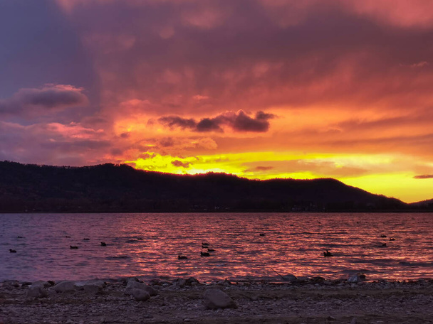 Червоний захід сонця на озері Констанс з потужними хмарами. - Фото, зображення