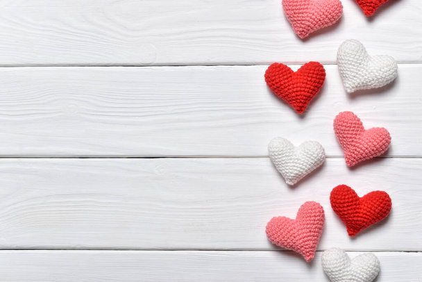 Background with knitted hearts on white. Flat lay - Fotoğraf, Görsel
