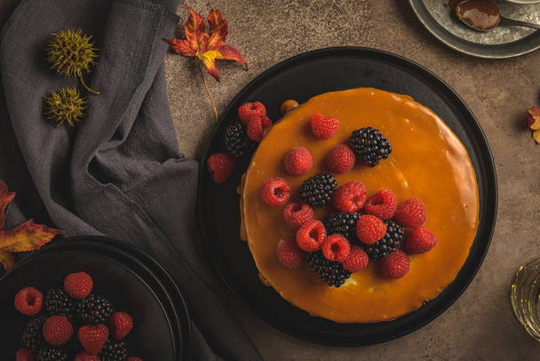 Delicious caramel cake with blackberries and raspberries. - Фото, изображение
