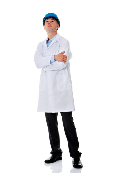 Hombre con una bata de laboratorio y casco
 - Foto, imagen
