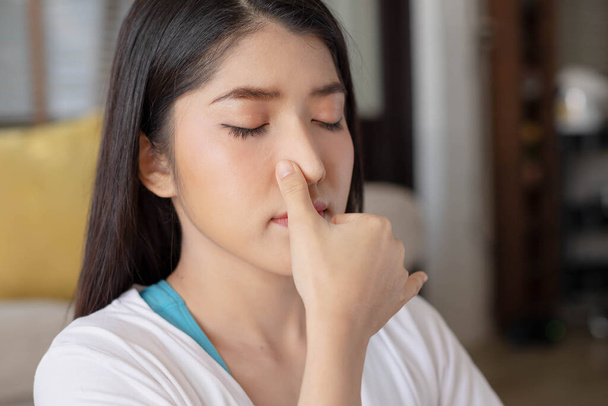 To guide her breath, an Asian lady touches her nostrils with her fingers. To get started with yoga and meditation - Photo, Image