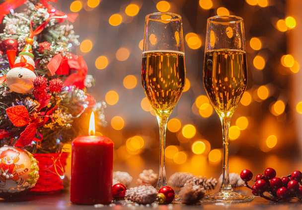 Glasses of champagne on the background of the Christmas tree and burning sparklers. The celebration of Christmas and New Year. Christmas illumination and decoration - Zdjęcie, obraz