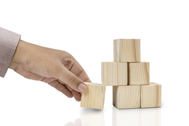 Hand put the stack of wooden block toy isolated over white background - Photo, Image