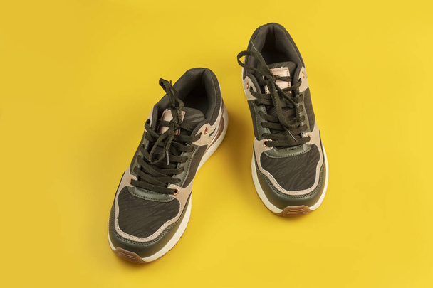 Pair of sports shoes on a yellow background. Top view. - Photo, Image