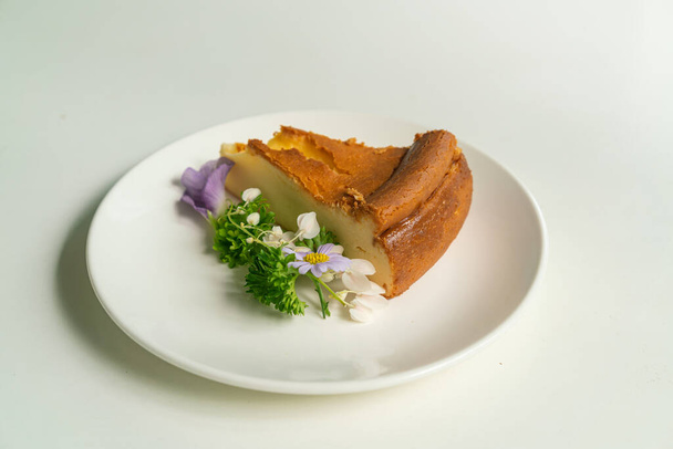 Basque Burnt Cheesecake decoratoin with flowers on white plate - Foto, Imagen