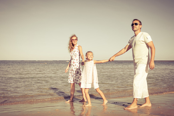 Щаслива сім'я, що гуляє на пляжі в день
. - Фото, зображення