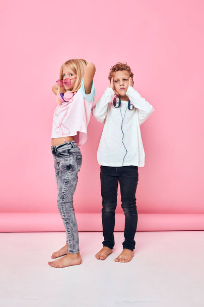 cute kids in casual clothes headphones pink background - 写真・画像