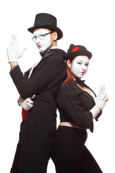 Portrait de deux artistes de mime se produisant, isolés sur fond blanc. Faisant semblant de tenir des armes. Symbole de l'équipe, des partenaires, Bonnie et Clyde - Photo, image