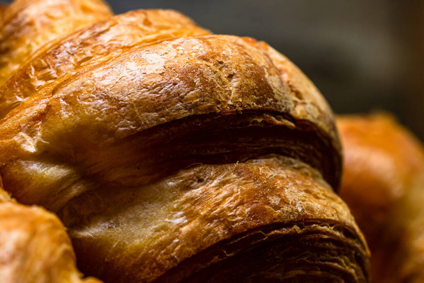 Tuoreita kullanruskeita ranskalaisia croissantteja. Maukkaita paistettuja croissantteja, lämpimiä voikroissantteja ja leivonnaisia - Valokuva, kuva
