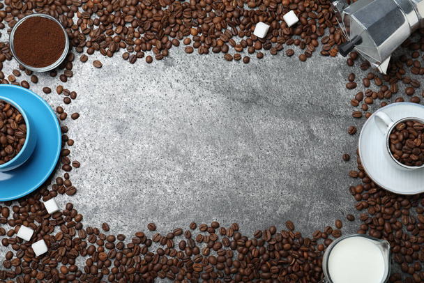 Flat lay composition with roasted coffee beans on grey table. Space for text - Фото, изображение