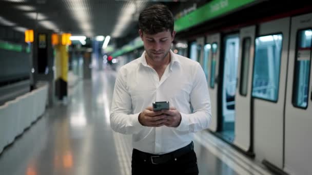 Бизнесмен использует смартфон на станции метро - Кадры, видео