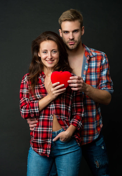 sexy joven pareja en amor mantener el corazón en negro fondo, relaciones - Foto, Imagen