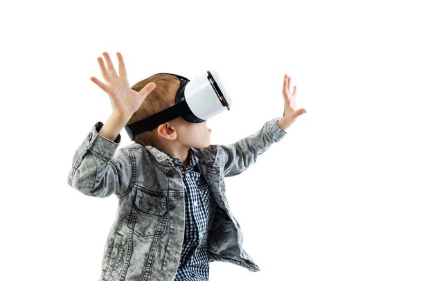 Young boy with virtual reality glasses isolated on white background. A child in emotional excitement wearing 3D glasses. - Foto, immagini