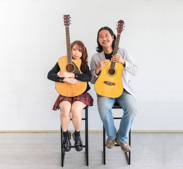 Portrait of Asian family duo band with two guitarist of father and daughter on white background for music, artist, musician style - Foto, Bild