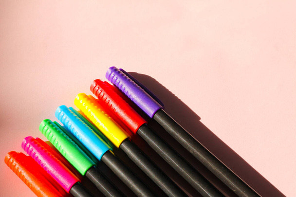 Un gros plan de stylos colorés sur un fond rose - Photo, image
