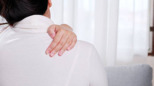 Woman performing self-massage on the shoulder due to pain in the body - Photo, image