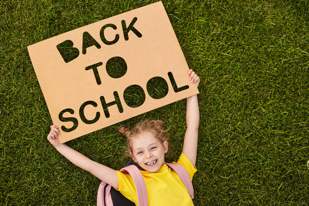 Schoolgirl with Back to school placard - Фото, зображення