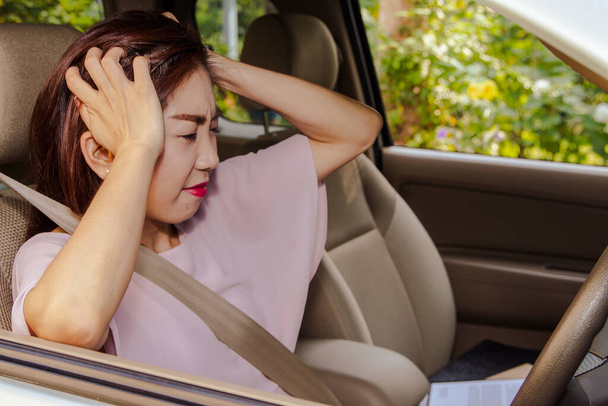 Arabasında migren ağrısıyla stresli oturan Asyalı kadının hayat sorunları var: Asyalı kadın, kendisine baskı uygulayan zayıf düşürücü bir sorunu olan bir arabada stresli.. - Fotoğraf, Görsel