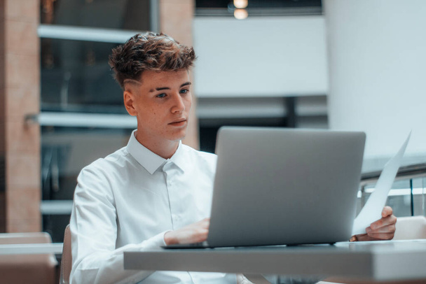 Junger gutaussehender Geschäftsmann sitzt professionell am Computer - Foto, Bild
