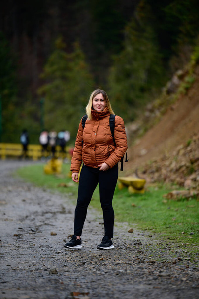 Turismo en los Cárpatos, una niña en un fondo de montañas en el centro de rehabilitación de osos pardos, Synevyr glade en la región de Transcarpathian. - Foto, imagen
