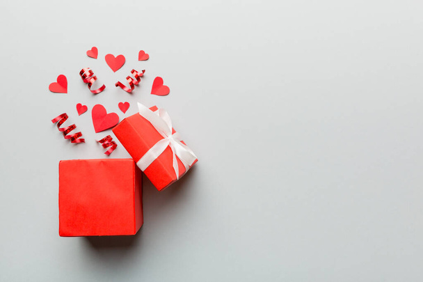 Hyvää Ystävänpäivä avasi sydämen muotoinen lahjapaketti, jossa on pienet sydämet, värillisellä taustalla, Ystävänpäivä kortti - ylhäältä näkymä käsite. - Valokuva, kuva