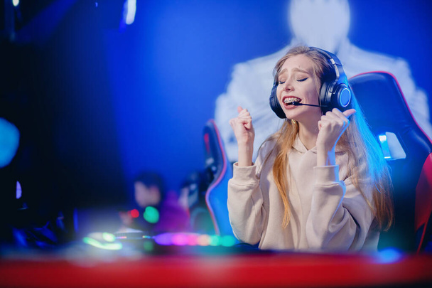 Streamer mladá žena raduje ve vítězství profesionální hráč hraje online hry počítač se sluchátky, neon barva - Fotografie, Obrázek