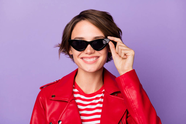 Photo of young cheerful girl happy positive smile hand touch sunglass isolated over purple color background - Photo, Image