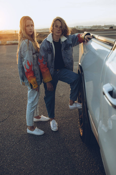 Boy and girl teenagers in fashionable clothes. Friends are posing for the camera. - 写真・画像