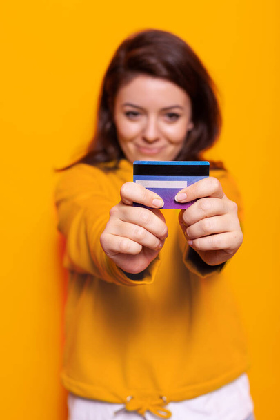 Portrait of cheerful woman holding credit card on camera - Фото, зображення